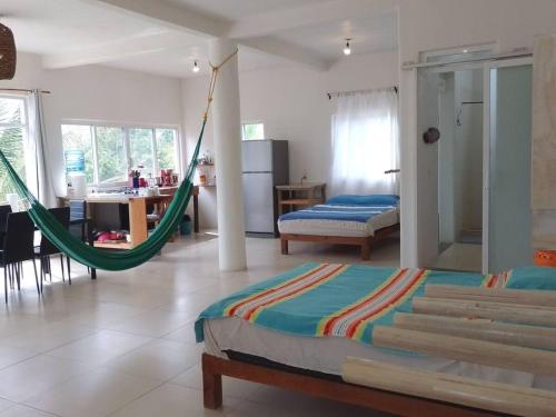 a room with two beds and a hammock in it at Penthouse - SolSurf House Mita in Punta Mita