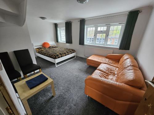 a living room with a couch and a bed at SnoozeDen Westmead - Windsor Castle & Legoland in Windsor
