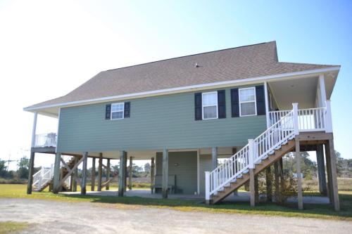 a large house with a porch and a staircase at 3BR Loft Cozy House Fishing Boating Views in Sealevel