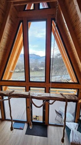 a swing in a room with a large window at Old Nut Cabin in Teşila