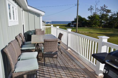 - une terrasse couverte avec une table et des chaises et l'océan dans l'établissement 4BR Soundfront cottage Private Dock Fishing, à Davis