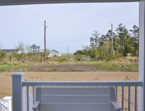 a bench on a porch with a view of a field at 2BR Cozy Cottage Private Dock in Davis