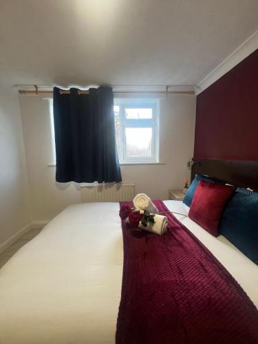 a bedroom with a large bed with red and blue pillows at Charming 2 bedrooms flat Skegness F11 in Skegness