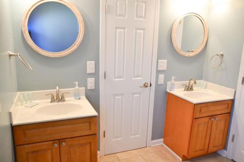une salle de bain avec deux lavabos et deux miroirs dans l'établissement 3BR Cottage Waterfront Wade Creek Fishing Boating, à Smyrna