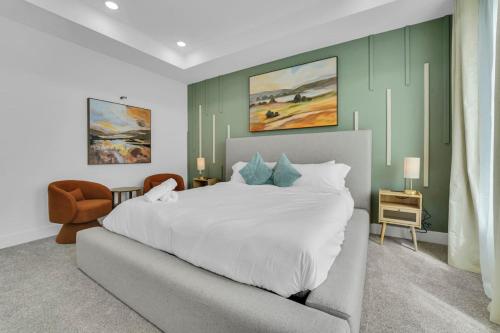 a bedroom with a large white bed and a chair at Classy 4BD 3.5BA with Soak Tub Backyard and Game Room in Houston