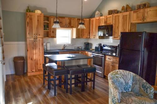 a kitchen with wooden cabinets and a black refrigerator at Cozy 3BR Cottage Fishing Private Dock Boating in Davis