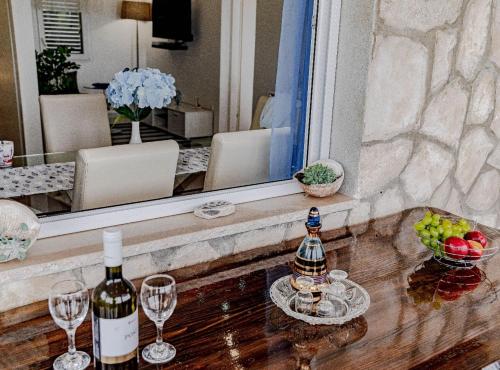 a bottle of wine sitting on a table with wine glasses at Stone House Blaca in Blato