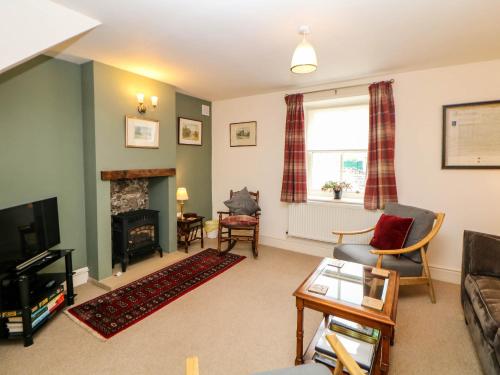 a living room with a couch and a fireplace at Brookside Barn in Bradwell