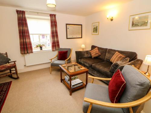 a living room with a couch and chairs at Brookside Barn in Bradwell