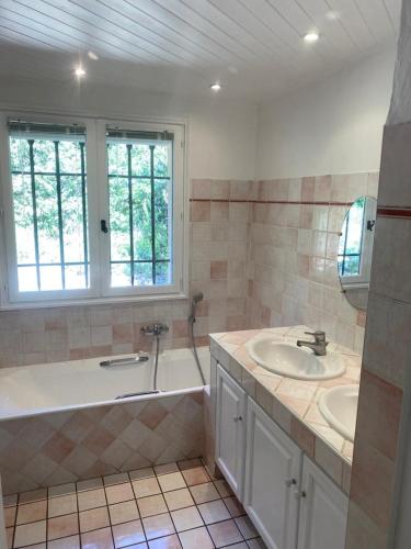 La salle de bains est pourvue d'une baignoire, de 2 lavabos et d'une baignoire. dans l'établissement Villa les figuiers, à Lorgues