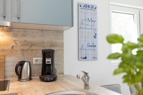a coffee maker on a counter in a kitchen at Ferienhäuser Lübecker Bucht Ferienhaus Strandläufer in Haffkrug