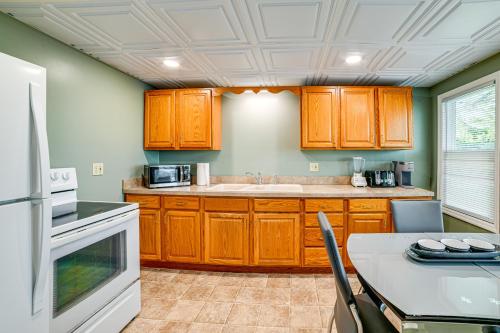 a kitchen with wooden cabinets and a table with chairs at Less Than 2 Mi to SUNY Cortland Unit with Private Parking in Cortland