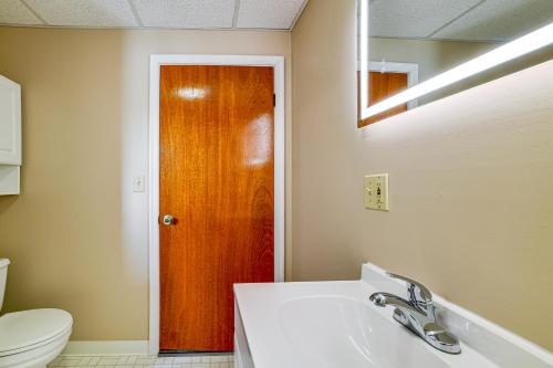 a bathroom with a toilet and a wooden door at Less Than 2 Mi to SUNY Cortland Unit with Private Parking in Cortland