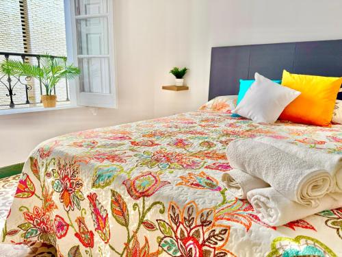a bedroom with a bed with a colorful bedspread at Centro apartamento 2-A in Huelva