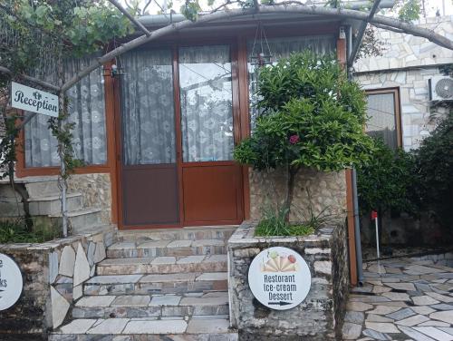 a front door of a house with a sign in front at Guest House Bake in Gjirokastër