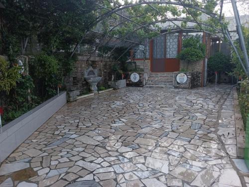 a stone patio with an arbor in front of a building at Guest House Bake in Gjirokastër