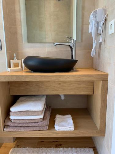 a bathroom with a sink and a mirror and towels at Medows Luxury Villa in Keri