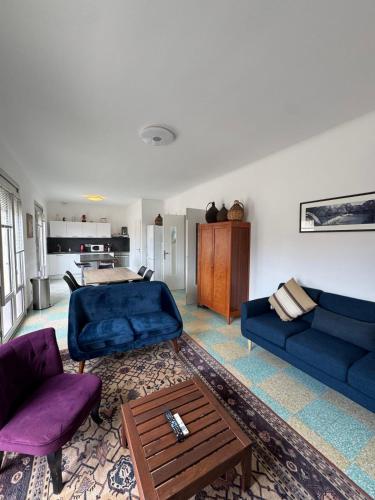un salon avec deux canapés bleus et une table dans l'établissement Place de l'Ancre Appartement 3 chambres avec garage 5 min plage & centre, au Grau-du-Roi