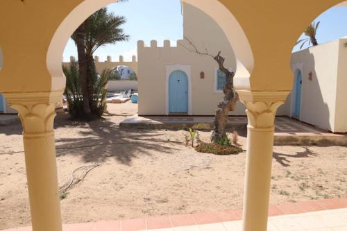 an archway with a building in the desert at Dar El Jerbiya in Midoun