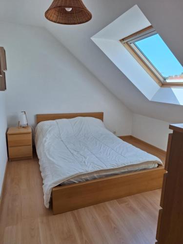 une chambre avec un lit et une lucarne dans l'établissement pléneuf centre, à Pléneuf-Val-André