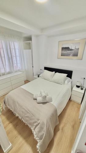 a bedroom with a large white bed with two towels on it at Lofts 4Towers - La Paz in Madrid