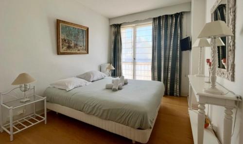 une chambre blanche avec un lit et une fenêtre dans l'établissement Le Santorin - Deauville, à Deauville