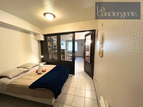 une chambre avec un lit et une porte donnant sur un couloir dans l'établissement Le Ga illard-Poitiers-LaConciergerie, à Poitiers