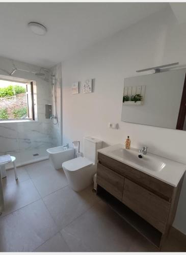 a bathroom with a sink and a toilet and a tub at El Resbalón in Comillas