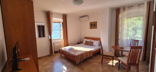 a bedroom with a bed and a table and a window at Gospar Apartments in Kotor