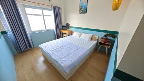 a small bedroom with a bed and a window at Sơn Đông Hotel in Quan Lạn