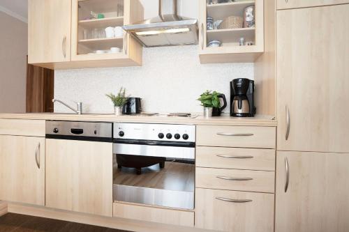 a kitchen with wooden cabinets and a stove top oven at Haus Baltic Ostseeidylle in Scharbeutz
