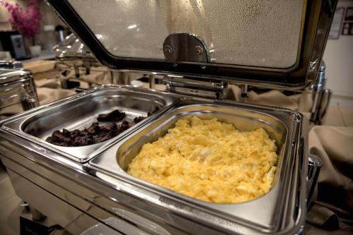 a dish of food in a pan on a stove at Hotel i Apartamenty Gorzelanny Dźwirzyno in Dźwirzyno