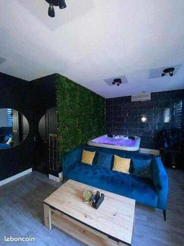 un salon avec un canapé bleu et une table dans l'établissement L'Inattendu Love Room, à Gardanne