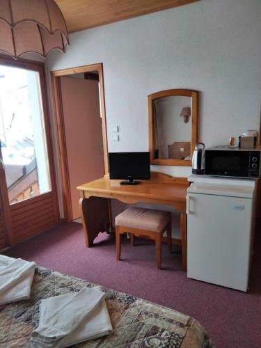 Cette chambre comprend un bureau et une cuisine équipée d'un four micro-ondes. dans l'établissement Studio n5 La cascade, à Bellevaux