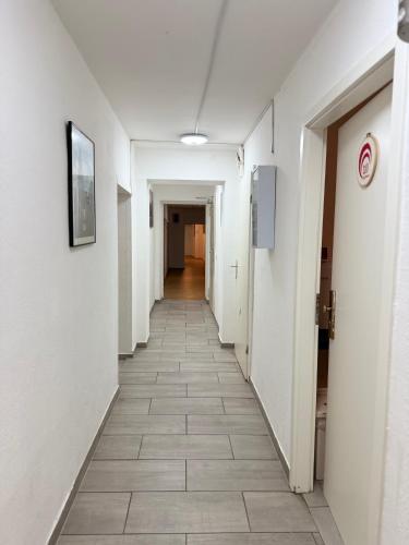 a corridor of an empty hallway with a tile floor at Hotel Garni Emir in Cologne