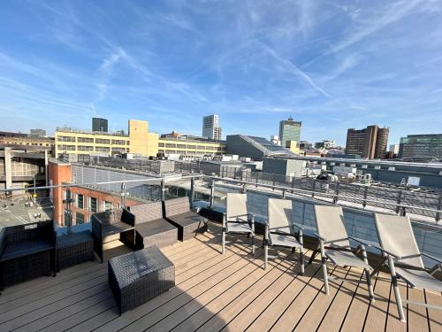a balcony with chairs and a view of a city at The Works - Two bed penthouse in Manchester