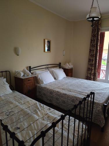 a bedroom with two beds and a window at Anesis Hotel in Loutra Edipsou