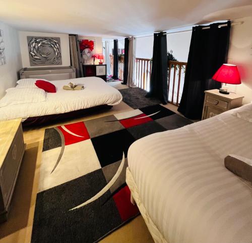 une chambre d'hôtel avec deux lits et un balcon dans l'établissement L'Ancre Rouge Deauville, à Deauville