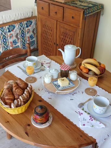 een tafel met een ontbijt van croissants, brood en jus d'orange bij Les Trois Salazes in Cambrai
