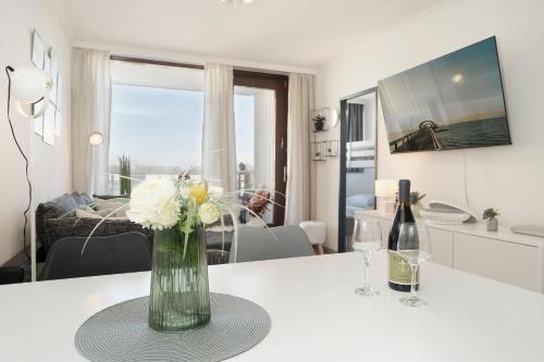 a vase of flowers on a table in a living room at Ferienwohnanlage Leuchtturmweg StrandGeflüster in Kellenhusen