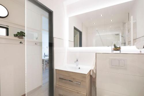 a bathroom with a sink and a mirror at Ferienwohnanlage Leuchtturmweg StrandGeflüster in Kellenhusen