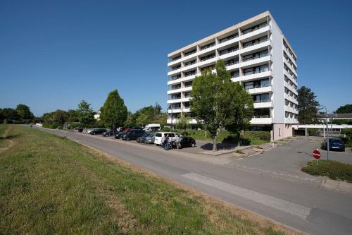 a large white apartment building with a parking lot at Ferienwohnanlage Leuchtturmweg StrandGeflüster in Kellenhusen