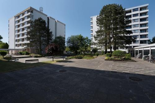 a park with benches and a large building at Ferienwohnanlage Leuchtturmweg StrandGeflüster in Kellenhusen