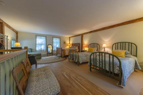 a bedroom with four beds and a living room at Walking distance to Lake Michigan! Cozy Cottage in Fennville