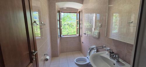 a bathroom with a sink and a toilet and a window at Gospar Apartments in Kotor