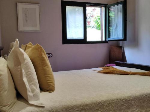 Un dormitorio con una cama con sábanas y almohadas blancas. en CASA do REMO, en Palmeira
