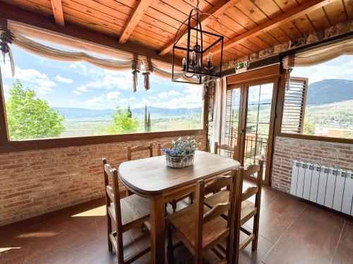 a dining room with a table and a large window at Casa Mama Puchi in Cercedilla