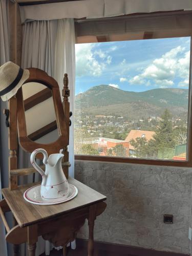 a tea kettle sitting on a chair in front of a window at Casa Mama Puchi in Cercedilla