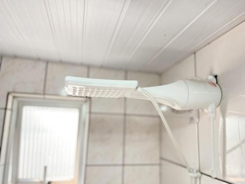 a white shower head in a bathroom with a mirror at ASA | Apto Funcional | Próx. Praia | Centro BC in Balneário Camboriú