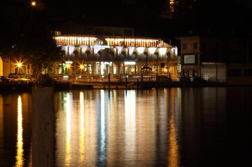 a lit up building on the water at night at Hotel Lovere Resort & Spa in Lovere